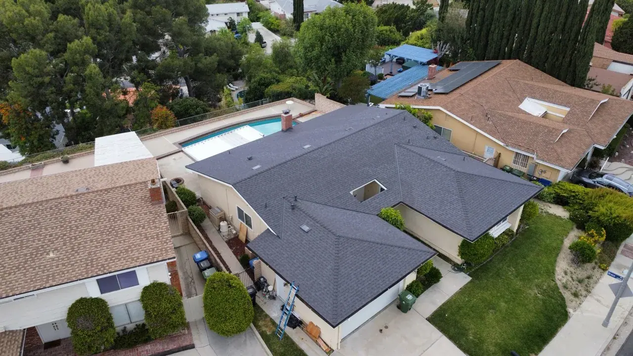 Aerial view of a gray shingle roof with intersecting roof slopes and vent penetrations from Inclusive Roofing's portfolio