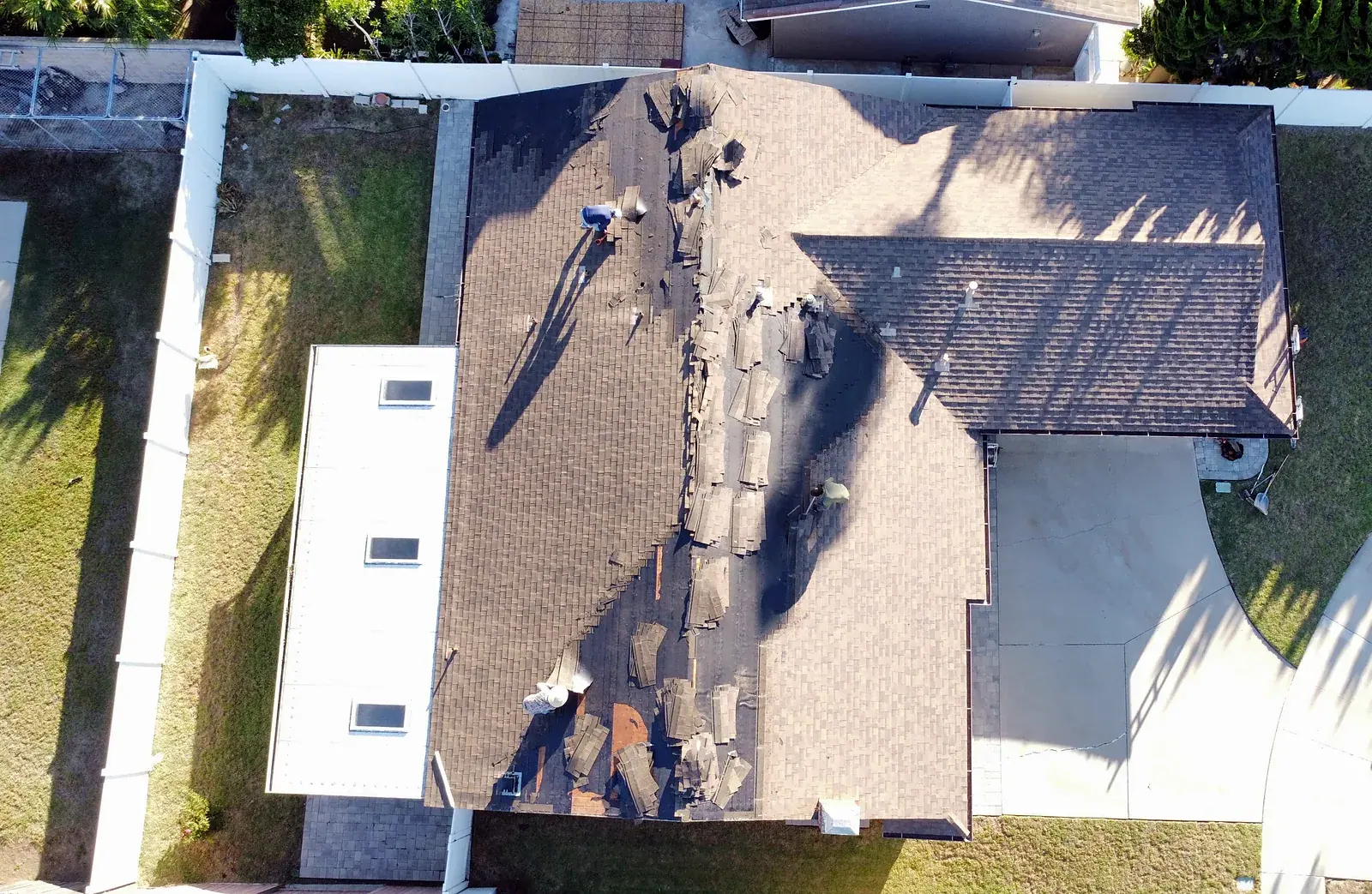 Before: old dark asphalt shingles being torn off an Oxnard home during roof replacement